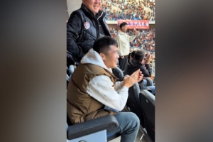 河南队球员钟义浩现场观战海牛比赛，并在海牛进球后展露笑颜。